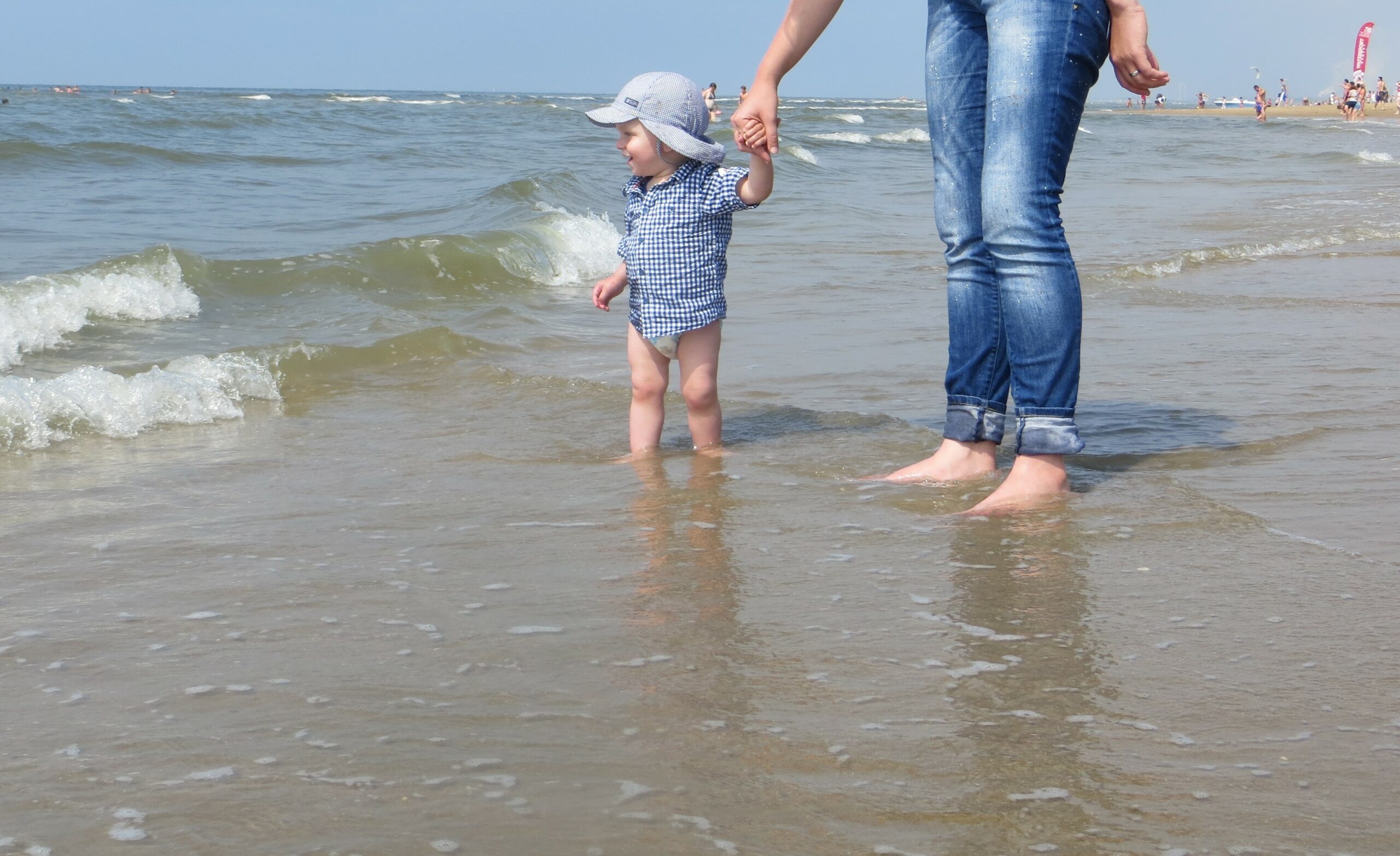 met je voeten in de zee